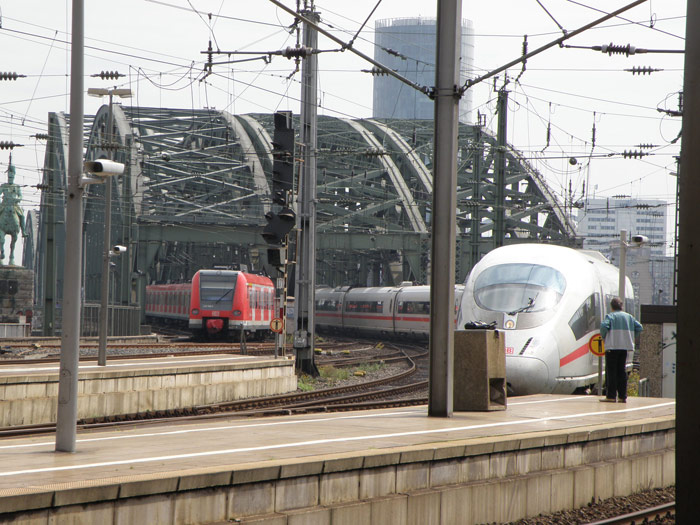Un tren de cercanas y un ICE entran en paralelo desde el puente Hohenzollern a la estacin
