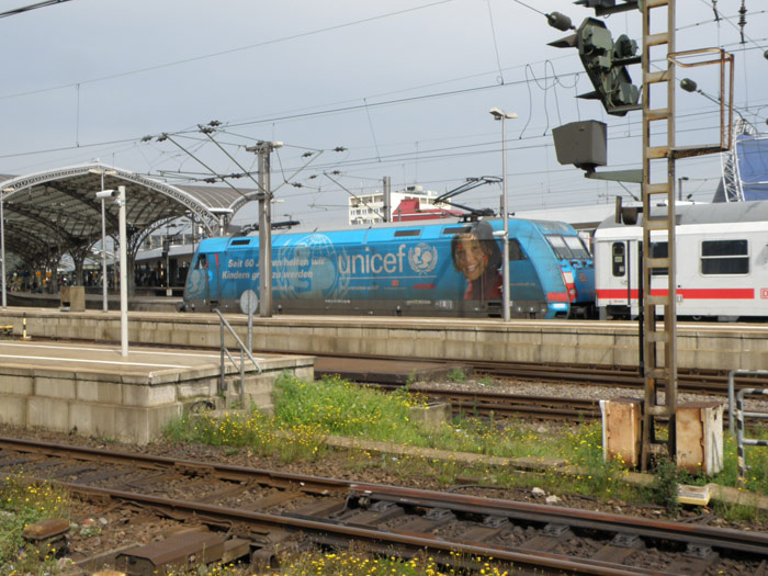 Una decorada locomotora de la DB entra con un tren de coches de viajeros a la estacin