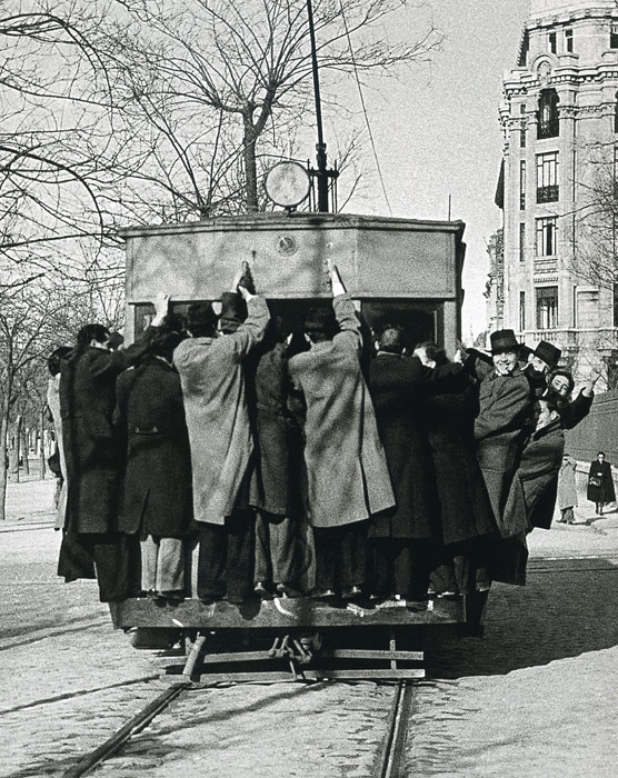 1941. Tarde de  fútbol. Decenas de aficionados se cuelgan del tranvía hacia el antiguo campo del Real Madrid, en Chamartín