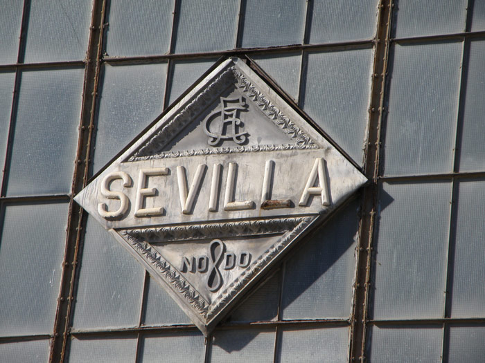 Rombo situado sobre el frontal de la marquesina, con el nombre de la ciudad, el logotipo de Ferrocarriles Andaluces y, debajo, el escudo de Sevilla.