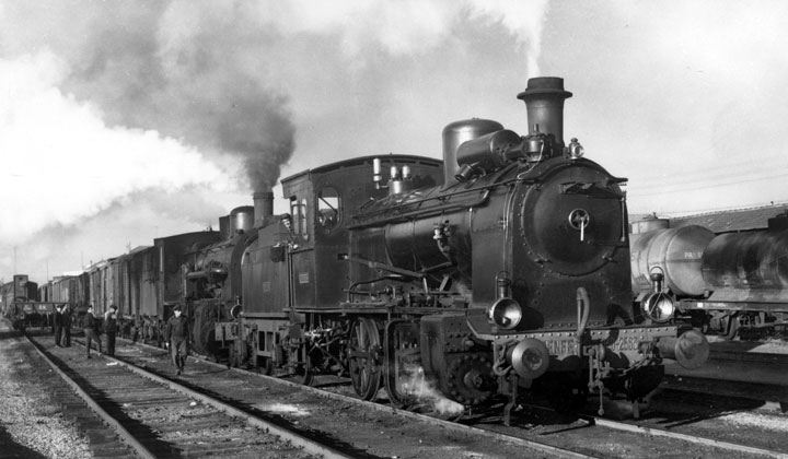 Locomotora de vapor 030-2563 en Salamanca y tras ella la 140-2495 y varios vagones cerrados de mercancías en Salamanca. Archivo Histórico Ferroviario FE-0009-019