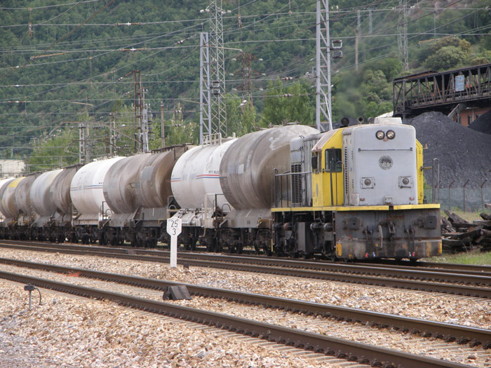 Una composición de cisternas de cementos, remolcado por una locomotora de la cementera, encamina el tren por las vías de La Robla desde un cargadero